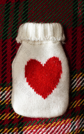 红色的热水填充袋为气候变暖放置冬天羊毛雕刻毯子冷的冬天时间概念心形状羊毛情况下