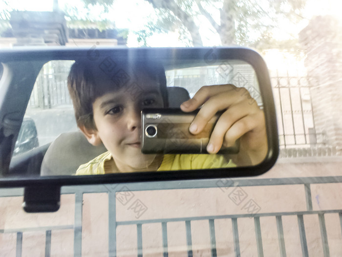 孩子采取图片与电话车镜子和男孩与电话