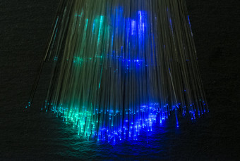 色彩鲜艳的视纤维照亮黑暗背景高速度互联网概念数据转移视纤维电缆群许多光学纤维发光的不同的颜色技术背景