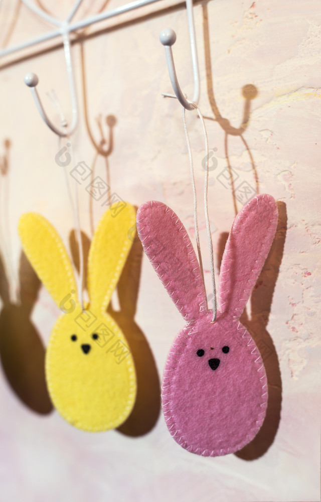 复活节兔子钩状的的墙房间多彩色的复活节兔子使织物粉红色的墙硬光从窗口和阴影的墙白色古董悬挂器