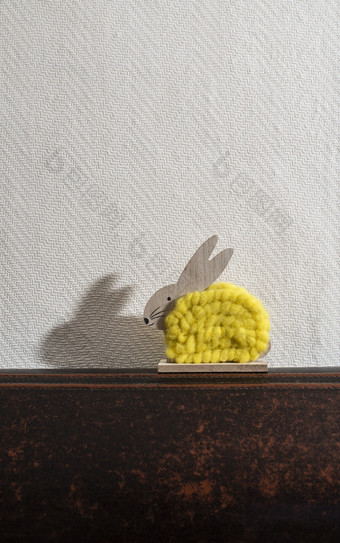 黄色的复活节兔子前面白色墙房间兔子装饰和白色壁纸背景影子兔子的墙木兔子数字形状和黄色的纱极简主义概念