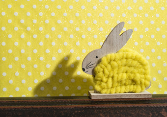 <strong>黄色</strong>的复活节兔子前面墙点房间兔子装饰和<strong>黄色</strong>的壁纸背景点影子兔子的墙木兔子数字形状和<strong>黄色</strong>的纱极简主义概念