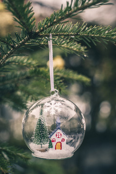 透明的cristalball与圣诞节树和房子内部雪圣诞节球