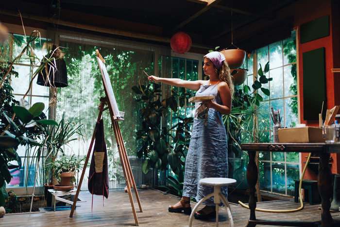 室内拍摄专业女艺术家绘画帆布工作室与植物