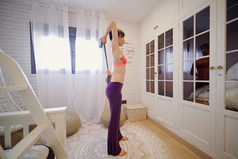 女人练习瑜伽她的公寓前面的窗口