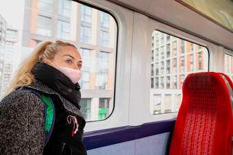 女人与卫生脸面具保持安全距离的<strong>座位火车</strong>因为的冠状病毒