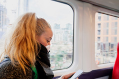 女人与卫生脸面具保持安全距离的座位火车因为的冠状病毒