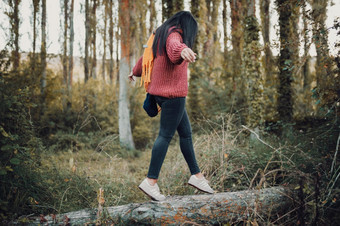 女人走<strong>树干</strong>通过的森林在的一天穿黄色的围巾和红色的羊毛泽西岛女人走<strong>树干</strong>通过的森林在的一天