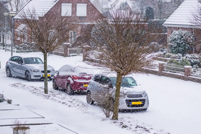 荷兰村街与停汽车覆盖雪冷冬天一天与雪天气的荷兰