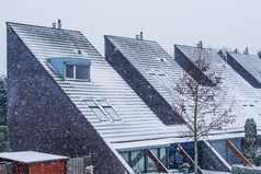 现代荷兰尖尖的屋顶覆盖雪现代社区在冬天季节雪冷天气的荷兰