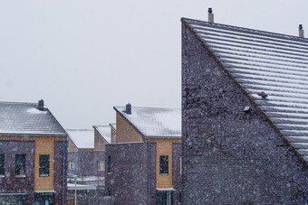 荷兰现代屋顶覆盖雪在雪天气社区的荷兰现代体系结构背景