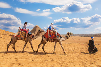 游客骑骆驼附近的金字塔吉萨游客骑骆驼附近的金字塔吉萨