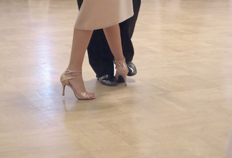 水平特写镜头两个无法辨认的舞者的鞋子壮举和腿他们的阿根廷探戈跳舞地板上在跳舞学院竞争行动拍摄的专业舞者探戈
