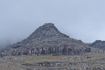 水平景观图像陡峭的山与岩石和雾和飞行鸟的变幻莫测岛的法罗岛屿光荣的风景的法罗语明信片主题