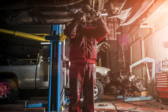 年轻的高加索人男人。红色的工作服装修复车与专业工具