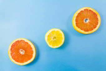 前视图一个柠檬和两个葡萄柚片蓝色的背景极简主义图片风格与复制空间为文本