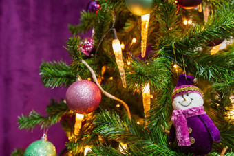 圣诞节树装饰紫色的主题与著名的紫色的雪人和装饰紫色的球和蜡烛灯视线