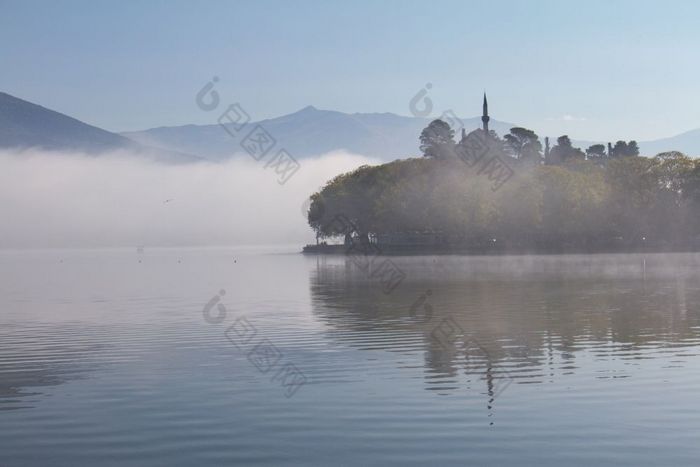 大气场景湖潘沃蒂斯有雾的早....约希腊与狮子帕夏清真寺的背景