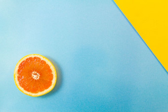 前视图单葡萄柚片蓝色的和对角黄色的背景极简主义图片风格与复制空间为文本