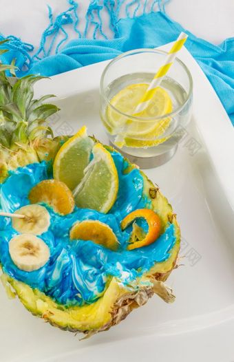 菠萝减少一半与切片水果和柠檬coctail白色板切片水果菠萝出现游泳菠萝池