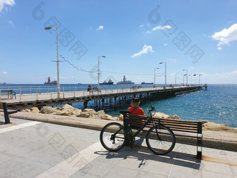 男人。坐在板凳上后面自行车<strong>凝视着</strong>对的海molos散步利马索尔岛塞浦路斯