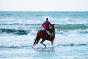 男人。骑棕色（的）飞驰的马的<strong>海</strong>水域圣地埃里尼<strong>海</strong>滩<strong>塞浦路斯</strong>对粗糙的<strong>海</strong>
