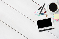 咖啡杯智能手机和笔笔记本白色木桌子上和有复制空间为设计你的工作