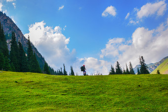 田园夏天景观与徒步旅行者的山与美丽的新鲜的绿色山牧场和森林概念户外活动和冒险tian-shan警察局吉尔吉斯斯坦田园夏天景观与徒步旅行者的山与美丽的新鲜的绿色山牧场和森林