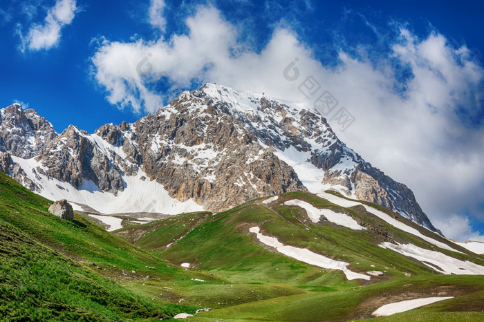 田园夏天景观与徒步旅行小道的山与美丽的新鲜的绿色山牧场蓝色的天空和云tian-shan吉尔吉斯斯坦田园夏天景观与徒步旅行小道的山与美丽的新鲜的绿色山牧场