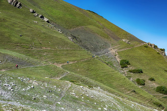 田园夏天景观与徒步旅行小道的山与美丽的新鲜的绿色山牧场蓝色的天空和云tian-shan吉尔吉斯斯坦田园夏天景观与徒步旅行小道的山与美丽的新鲜的绿色山牧场