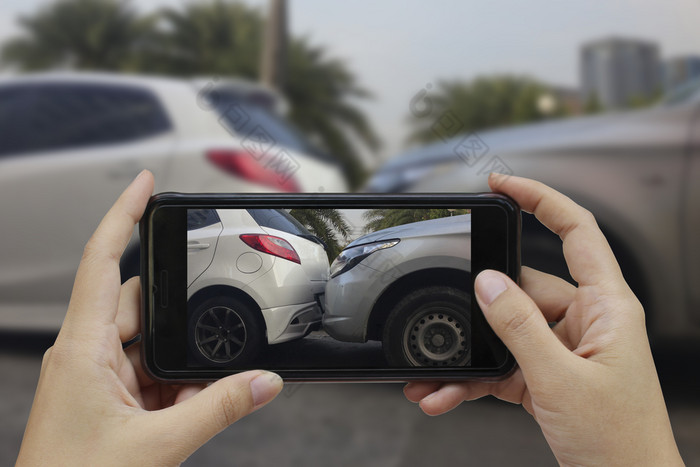 手持有聪明的电话取照片的场景车崩溃车事故为保险
