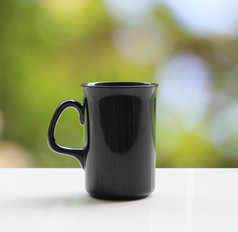 黑色的咖啡杯子白色表格自然背景