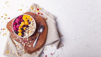 树莓芒果和蓝莓碗健康的早餐概念与酸奶和牛奶什锦早餐
