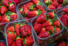 背景新鲜的草莓塑料盒子出售的城市市场