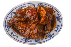 中国人烤鸭减少一块和服务白色菜超过与黑色的肉汁Herbal酱汁孤立的白色背景