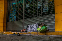曼谷泰国俊无家可归的人光着脚的女人睡觉的人行道上前面的关闭商店通过社会问题