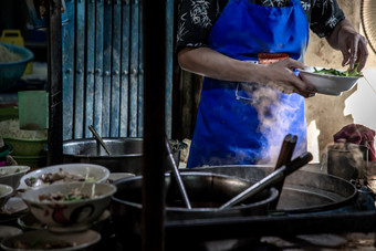 曼谷泰国10月老板烹饪蛋面条与烤猪肉当地的餐厅泰国街食物使面条传统的亚洲食物中国人蛋面条和热煮熟的汤