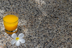 玻璃新鲜的橙色汁与花为点心石头背景休闲活动
