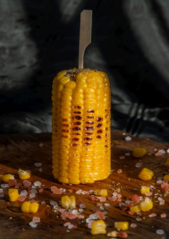 烤玉米的结实的矮乡村木董事会在黑暗背景的想法为烧烤和烧烤方烧烤概念