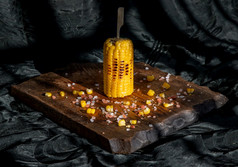 烤玉米的结实的矮乡村木董事会在黑暗背景的想法为烧烤和烧烤方烧烤概念