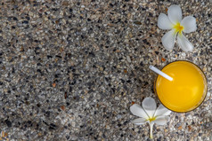 玻璃新鲜的橙色汁与花为点心石头背景休闲活动