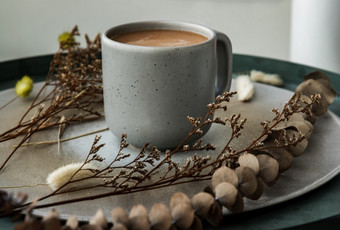 热橙色牛奶茶蓝色的陶瓷杯甜蜜的点心泰国牛奶茶陶瓷和干花陶瓷板焦点和模糊