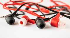 黑色的和红色的耳机白色背景特写镜头黑色的和红色的耳机白色背景