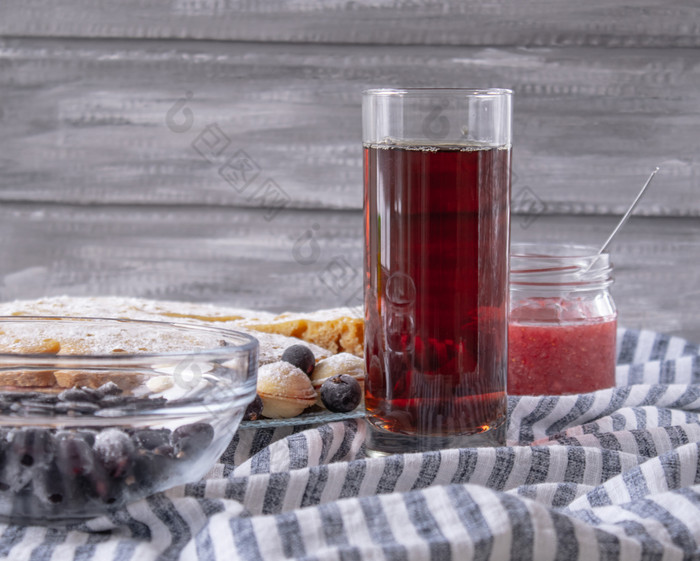 红色的汁玻璃下一个碗饼干和Jar小时特写镜头红色的汁玻璃下一个碗饼干和Jar小时灰色的背景