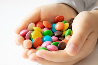 轮多色的巧克力特写镜头桩多色的糖果孩子持有糖果轮多色的巧克力桩多色的糖果孩子持有糖果