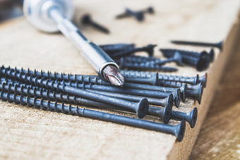 钢螺丝谎言木董事会附近的螺丝刀的概念工具和修复工作钢螺丝金属螺杆钢螺丝谎言木董事会附近的螺丝刀的概念工具和修复工作钢螺丝