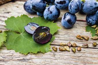 葡萄和葡萄种子绿色叶老木董事会蓝色的葡萄水疗中心生物生态产品概念葡萄和葡萄种子绿色叶老木董事会蓝色的葡萄水疗中心生态产品概念