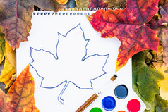 色彩斑斓的秋天叶子和油漆为绘画附近白色纸与的地方为文本背景与秋天叶子复制空间为登记学校概念色彩斑斓的秋天叶子和油漆为绘画附近白色纸与的地方为文本背景与秋天叶子复制空间为登记
