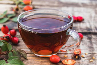 茶酊与玫瑰臀部玻璃杯附近红色的浆果木表格植物疗法茶酊与玫瑰臀部玻璃杯附近红色的浆果木表格