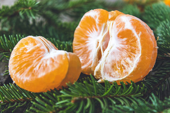 成熟的去皮片橘子没有皮谎言的绿色分支机构圣诞节树柑橘类水果橘子橙子特写镜头成熟的去皮片橘子没有皮谎言的绿色分支机构圣诞节树